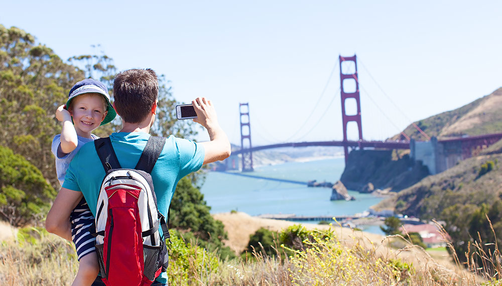 Father holding child and looking at Golden Gate Bridge